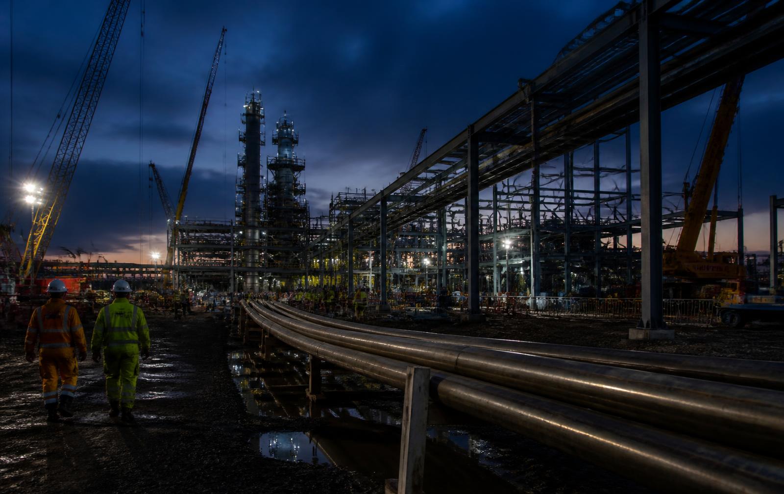 Construction crew walking an industrial jobsite at dusk